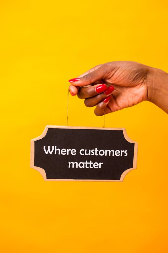 pexels photo 7563605 Hand holding a sign with 'Where customers matter' on a vibrant yellow backdrop.