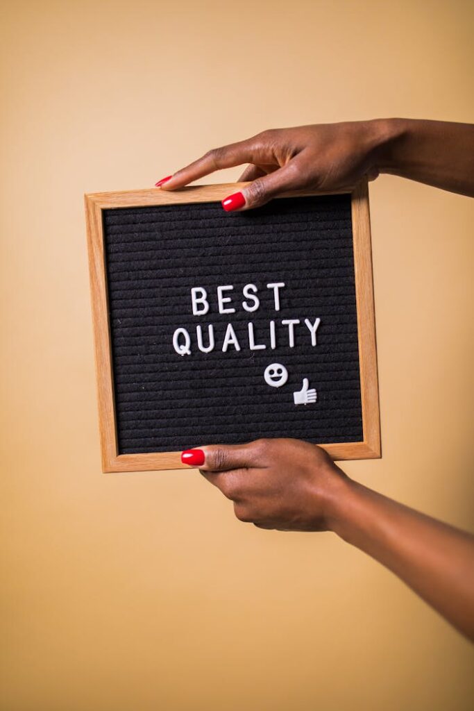 pexels photo 7564203 Hands holding a letter board with 'Best Quality' text, emoji, and thumbs up.